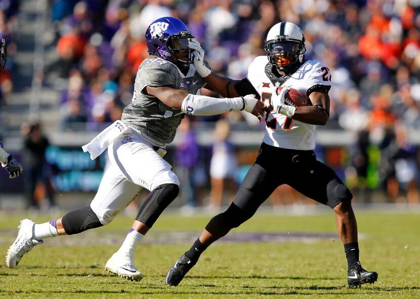 Oklahoma State Cowboys running back Justice Hill (27) gives TCU Horned Frogs defensive end...