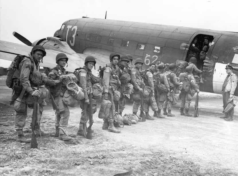 Allied paratroopers enter a transport plane before taking off on the assault on...