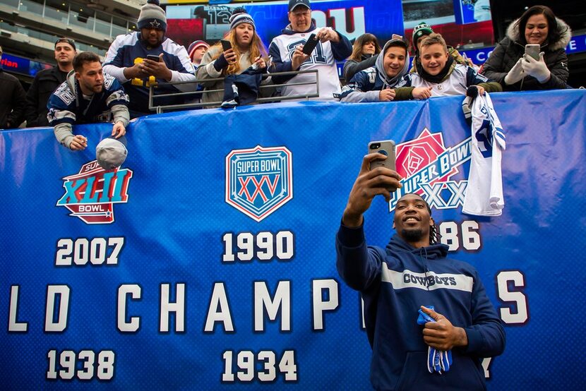 Dallas Cowboys defensive end Demarcus Lawrence takes a selfie with fans before an NFL...