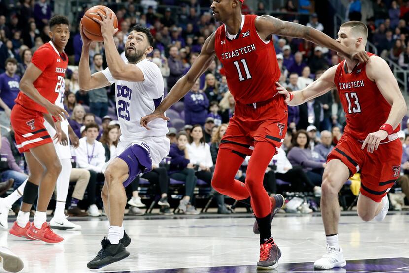 TCU guard Alex Robinson (25) works to the basket for a shot as Texas Tech Red Raiders...