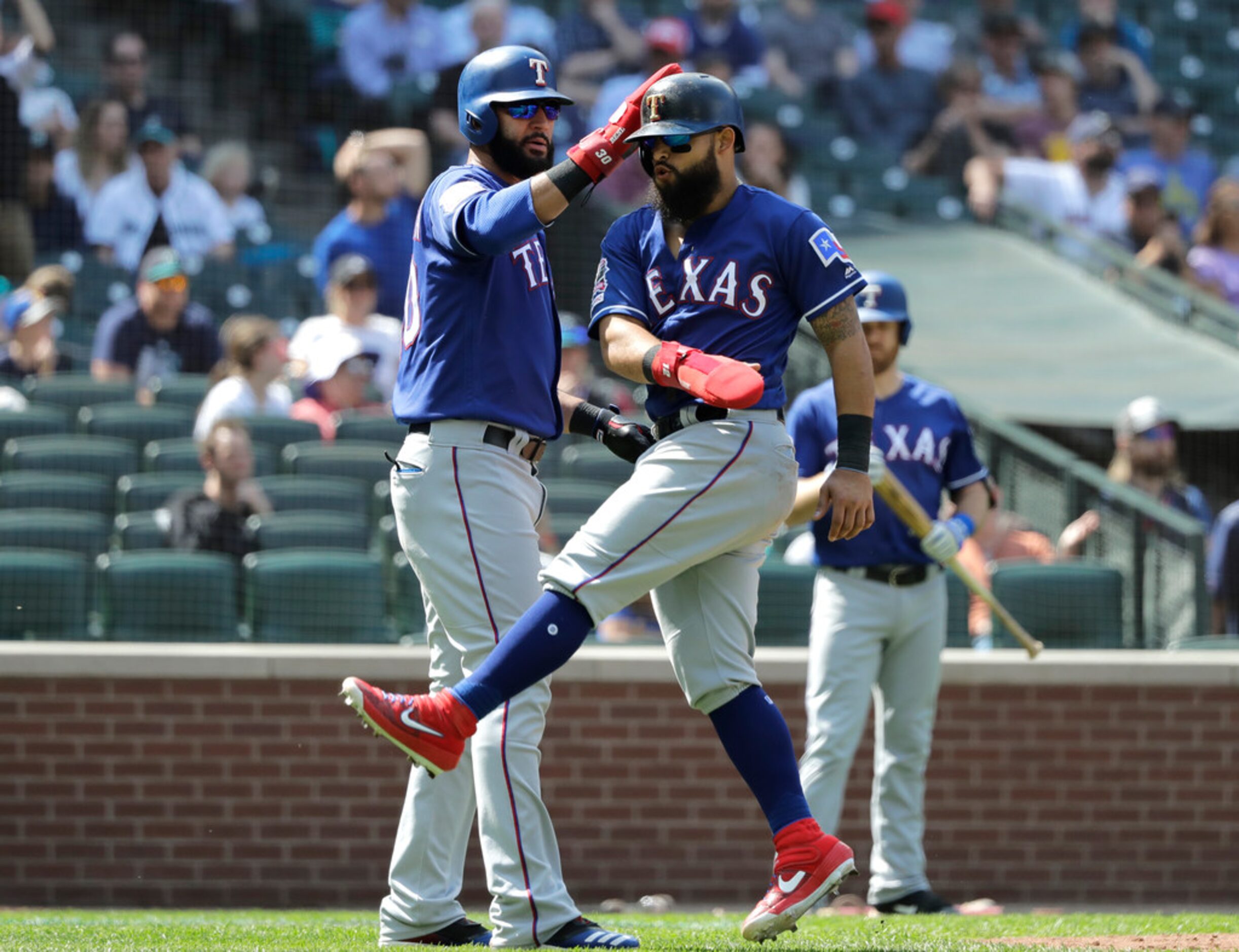 Texas Rangers' Nomar Mazara, left, and Rougned Odor, right, react after they both scored on...