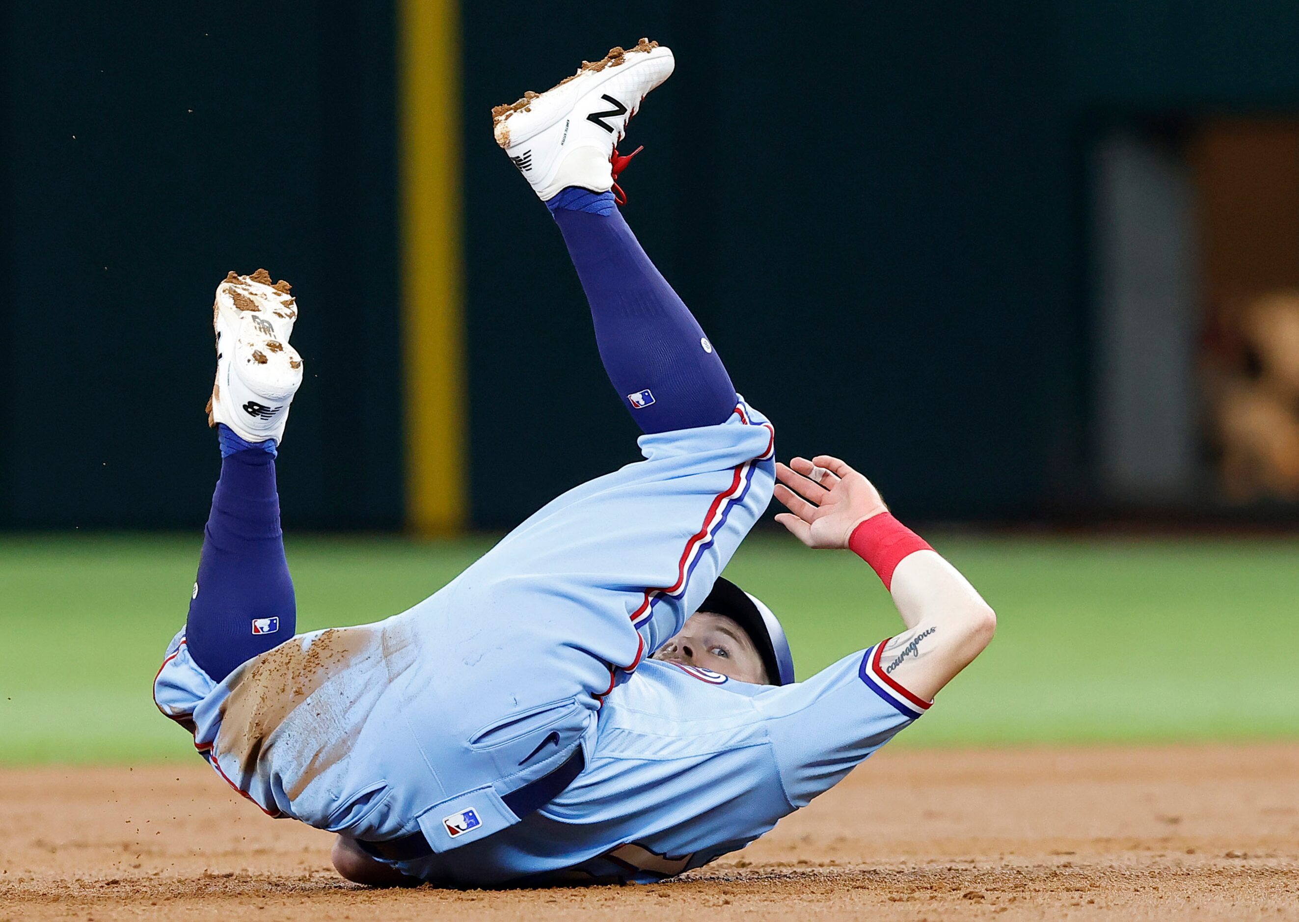 Texas Rangers Brock Holt (16) rolls over in the dirt as he was out at second base to end the...