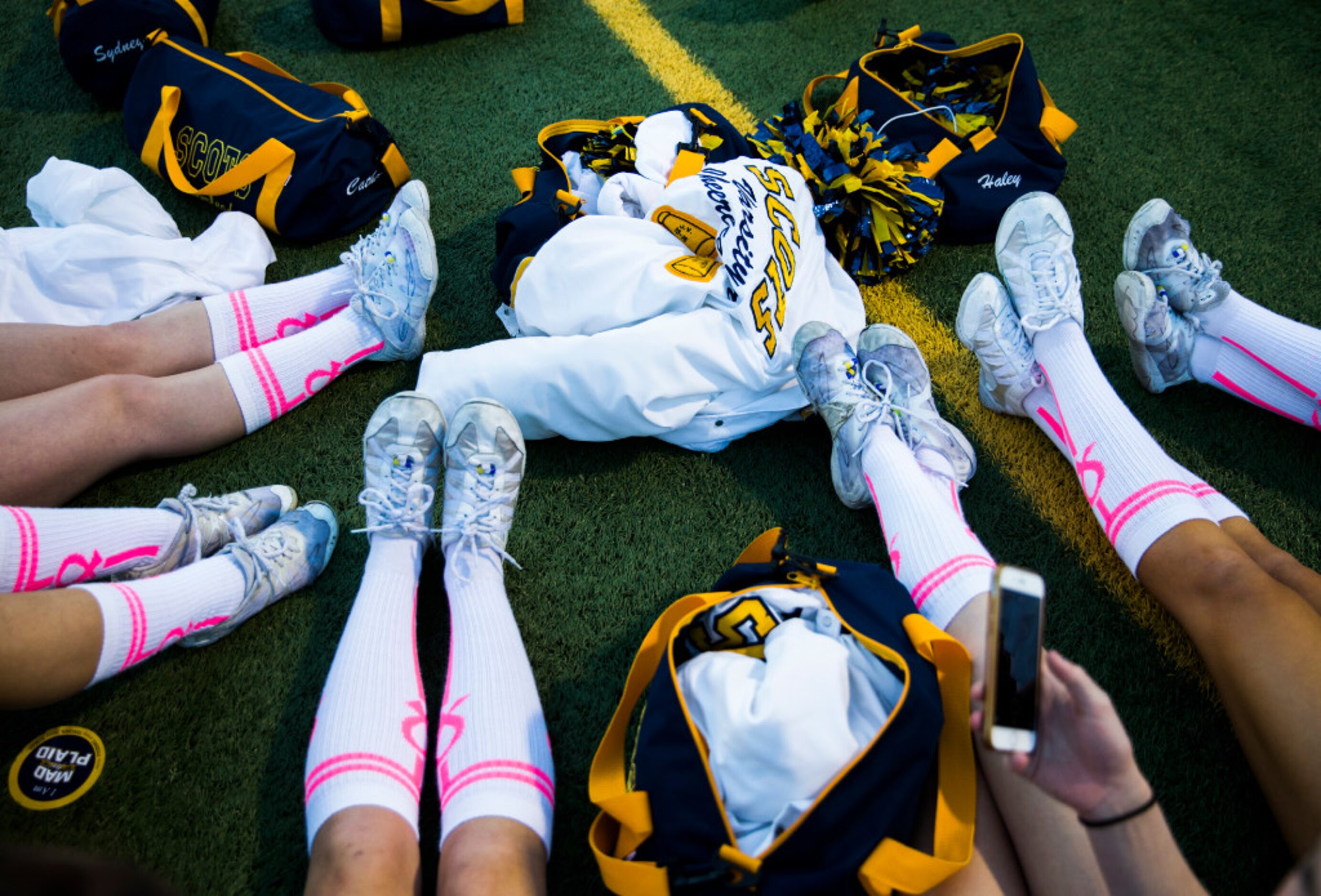 Highland Park cheerleaders wear pink and white socks in honor of Breast Cancer Awareness...