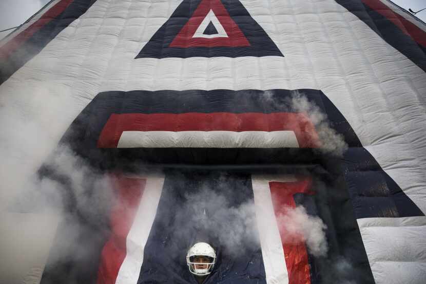 Allen kicker Michael Ewton (89) peaks out of a giant inflatable letter 'A' before entering...