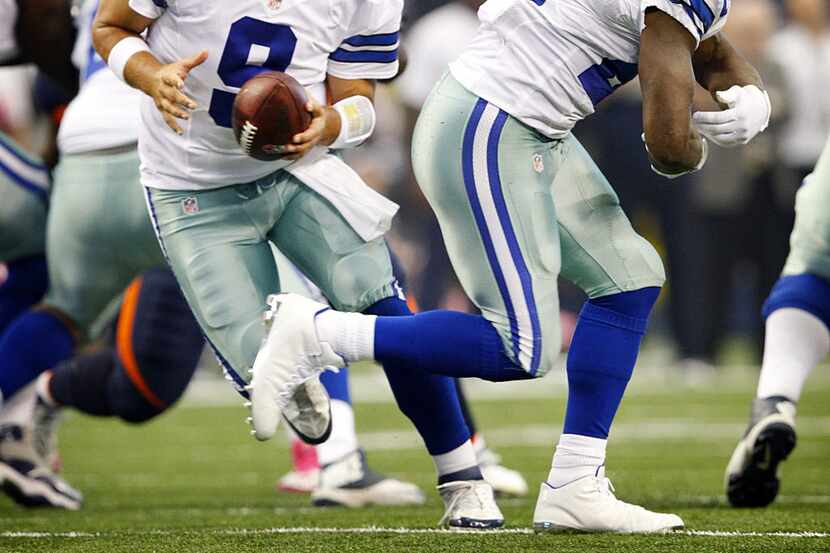 Dallas Cowboys quarterback Tony Romo (9) fakes the handoff to running back DeMarco Murray...