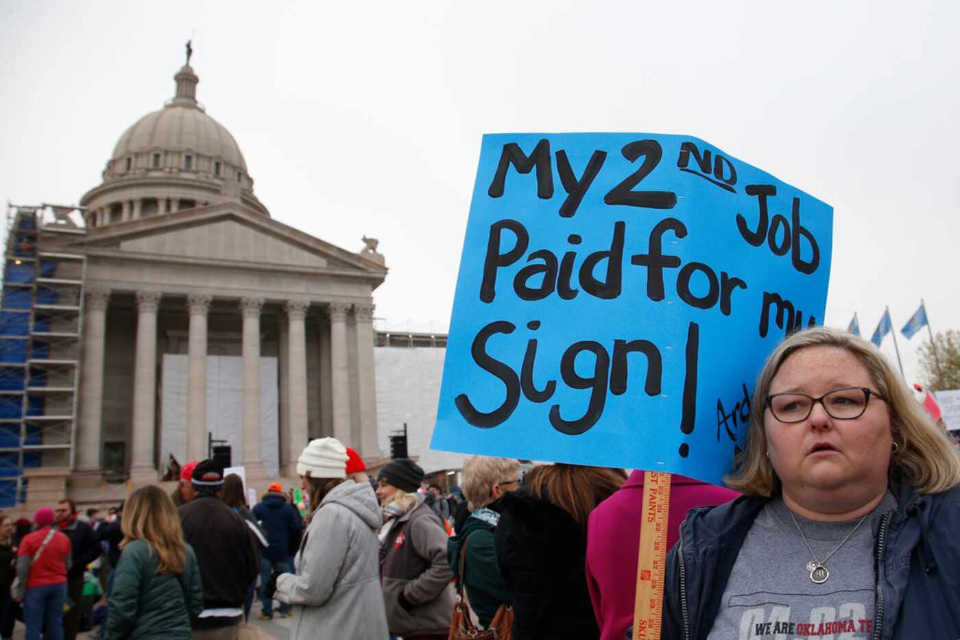 Melissa Knight, who teaches art at Ardmore, Okla., middle school, holds a sign as teachers...