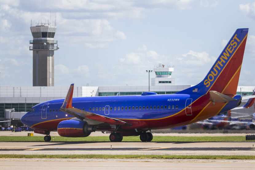 A Southwest Airlines airplane takes off as others remain parked at terminals while computer...