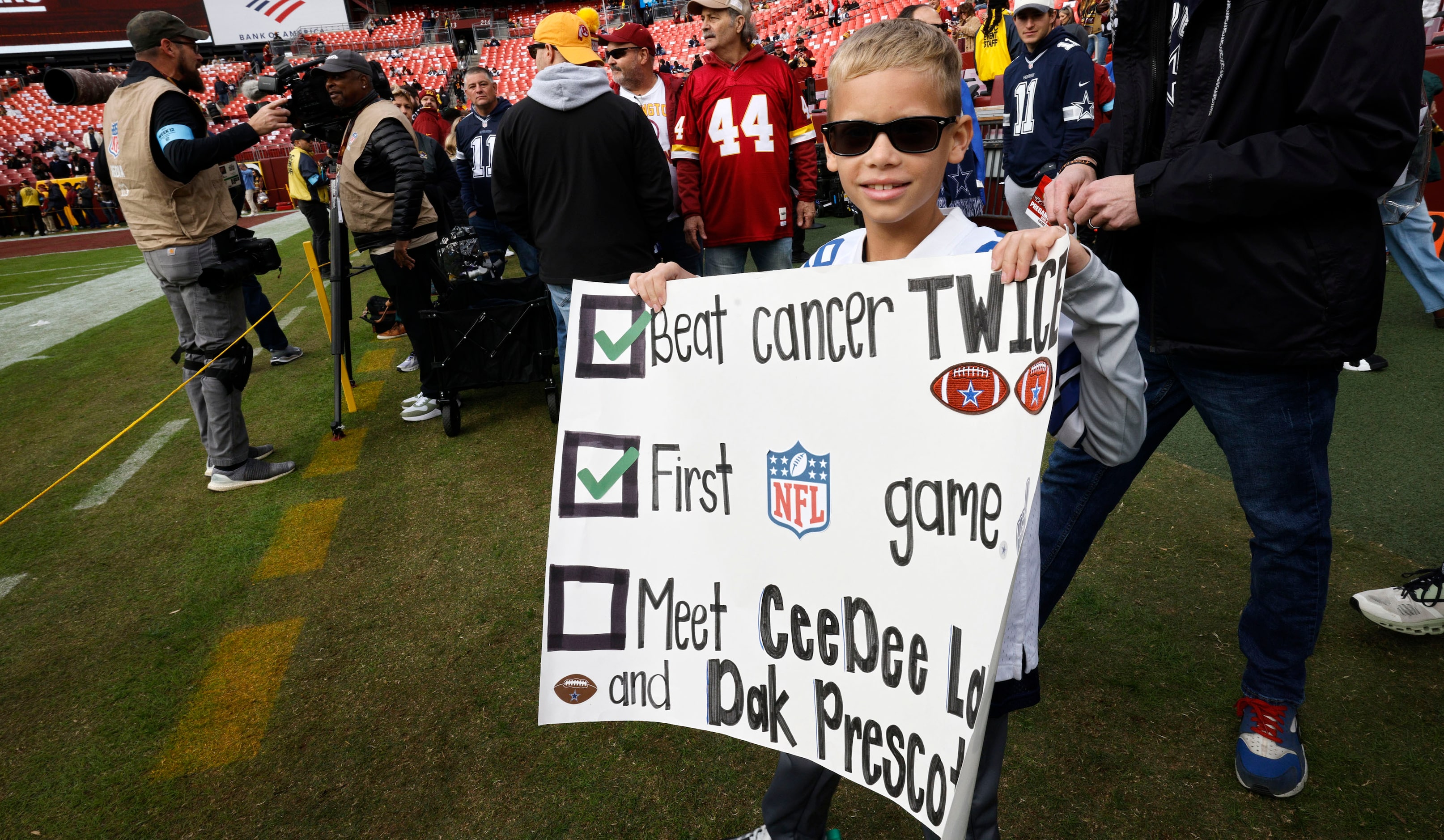 Tristen Graham, 9 of California holds a sign before an NFL football game between the Dallas...