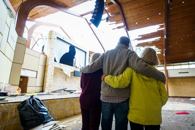 Northway Church lead pastor Shea Sumlin offers comfort to KC Pemberton, left, and Sonie...