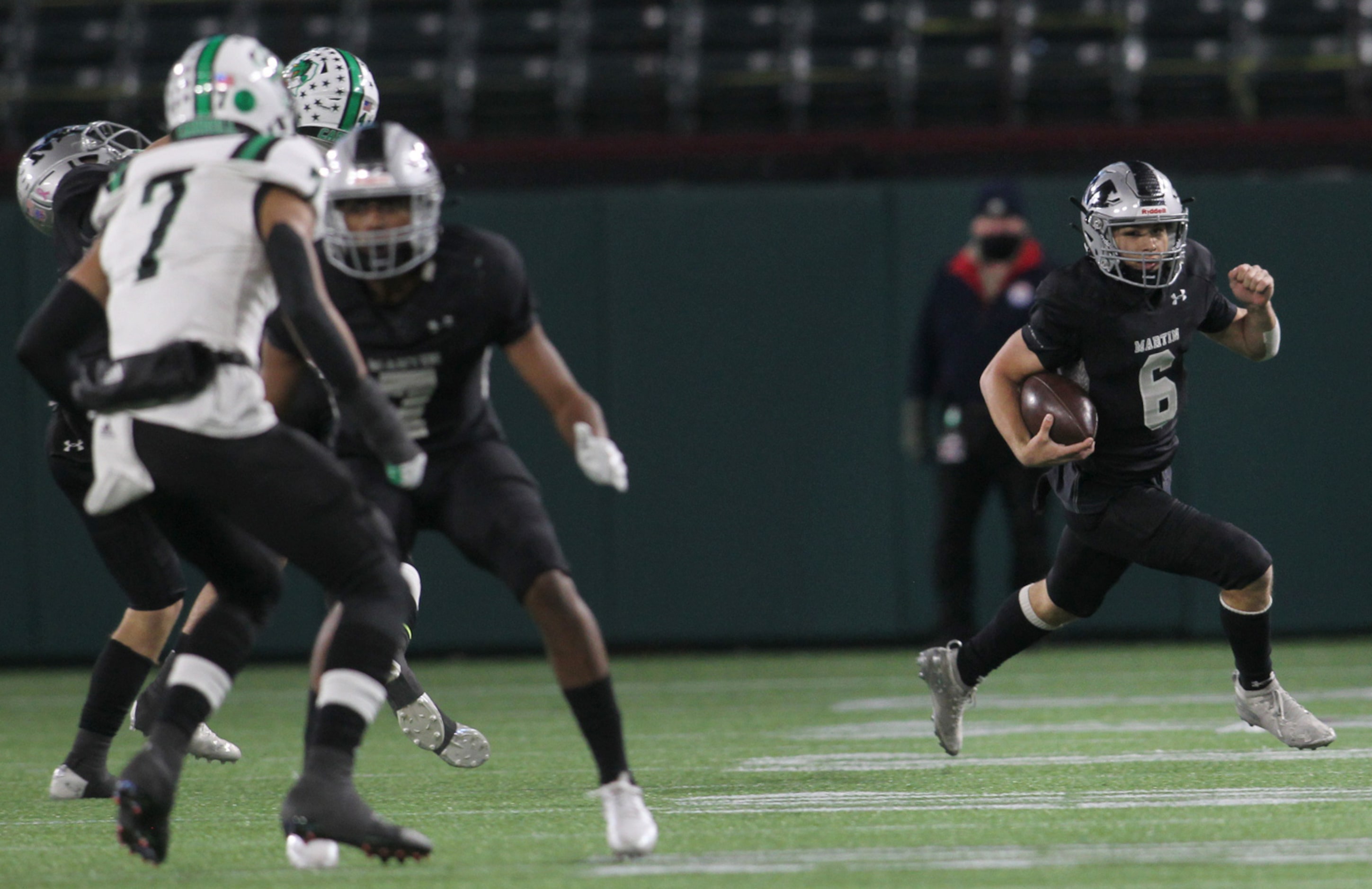 Arlington Martin quarterback Zach Mundell (6) scampers out of the backfield for a big...