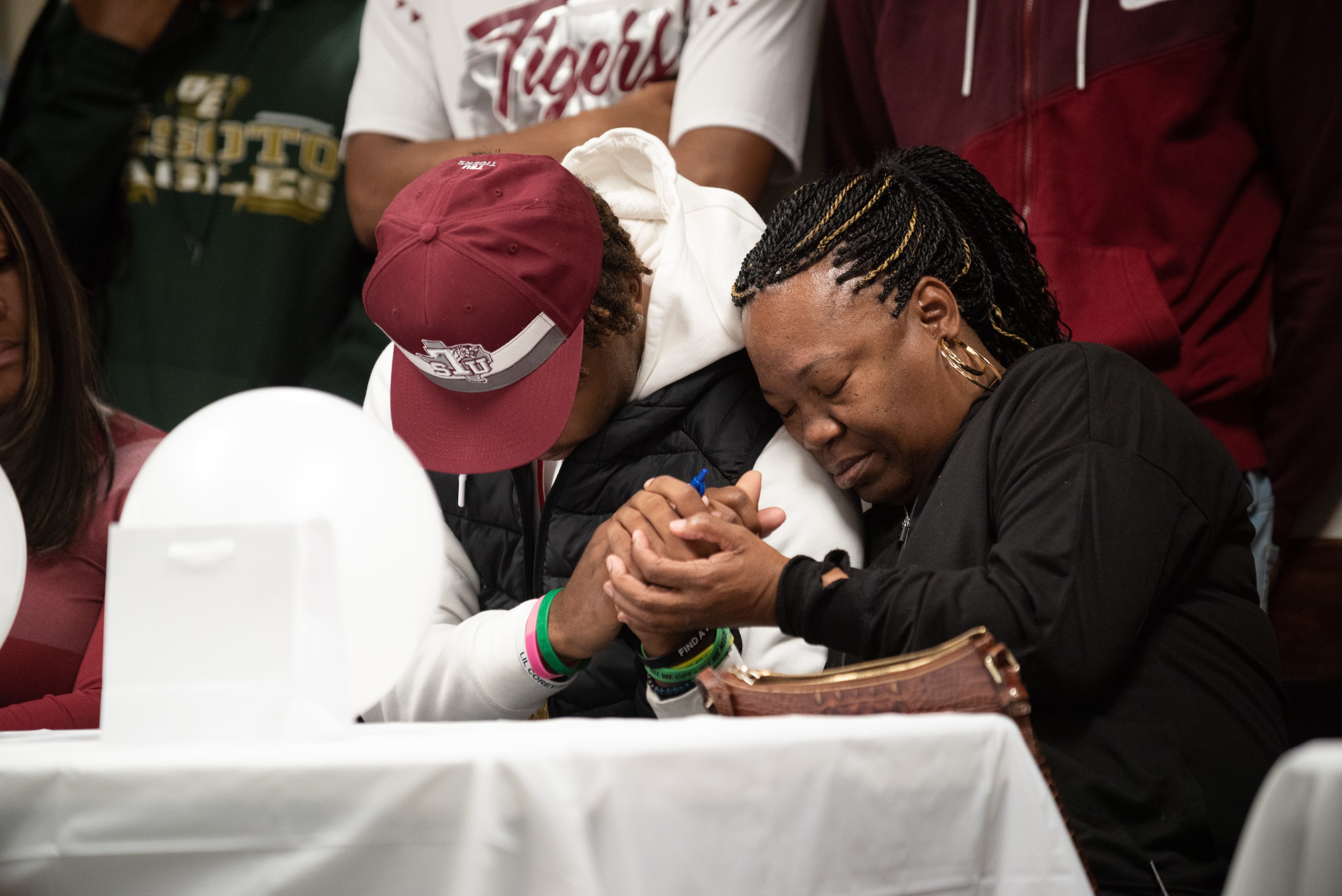 DeSoto high school football players DeMichael Porter holds the hand of Lynn Humphrey, his...