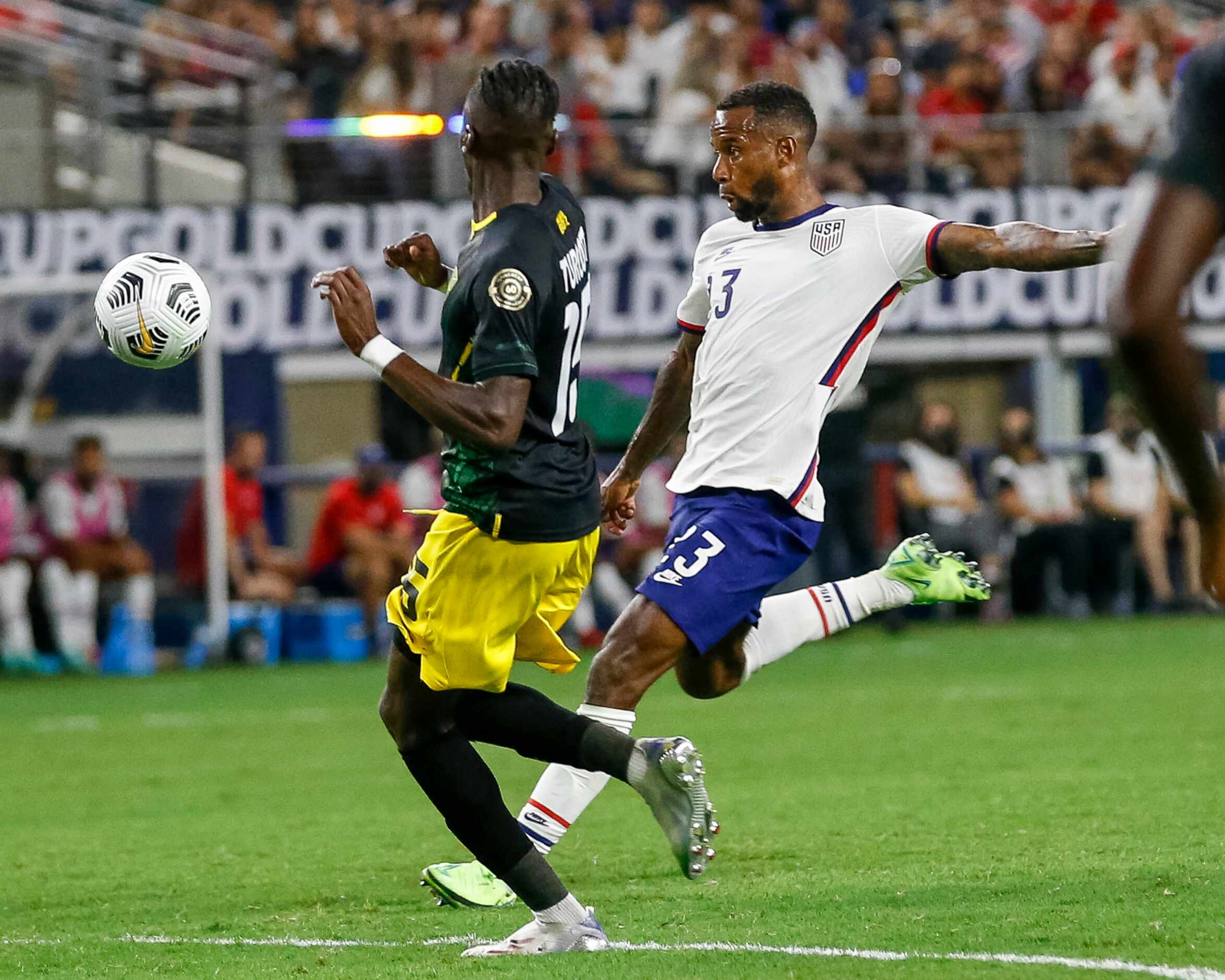 USA midfielder Kellen Acosta (13) shoots the ball around Jamaica forward Blair Turgott (15)...