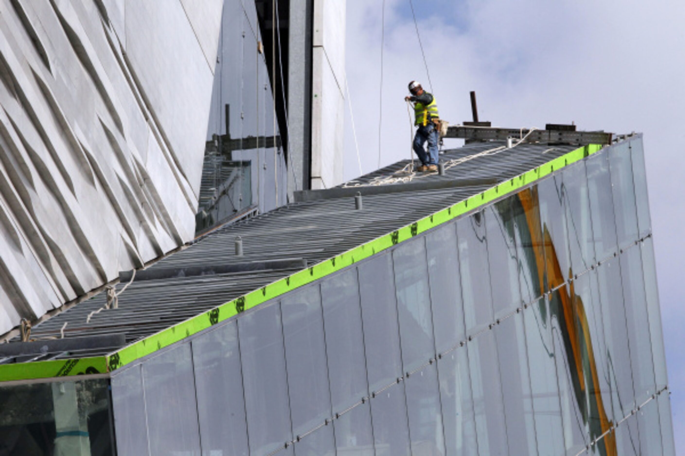 A construction worker walks down the glass-enclosed escalator at the $185-million Perot...