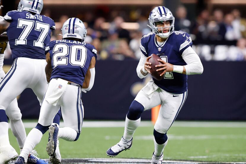 Dallas Cowboys quarterback Dak Prescott (4) fakes the handoff to running back Tony Pollard...