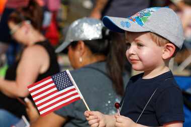Un niño con una bandera de Estados Unidos observa el Desfile de Labor Day en el centro de...