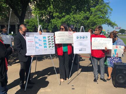 Representatives of Communities United for a Greater Dallas hold signs with messages saying...