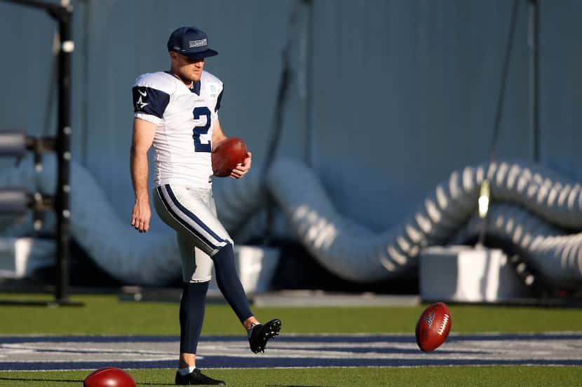 Dallas Cowboys place kicker Greg Zuerlein (2) gathers footballs in practice during training...
