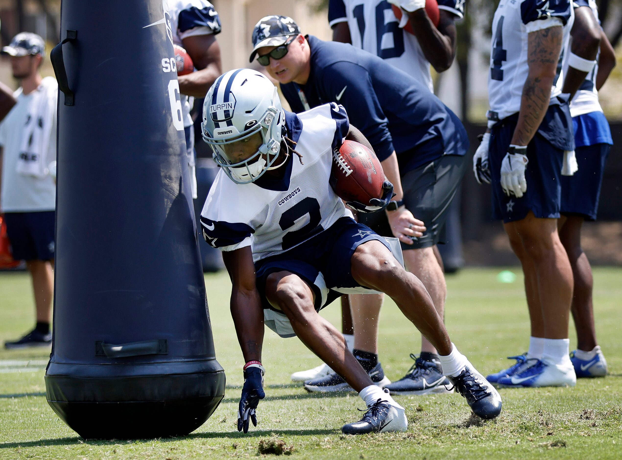 Dallas Cowboys wide receiver KaVontae Turpin digs around a blocking dummy as he carries the...