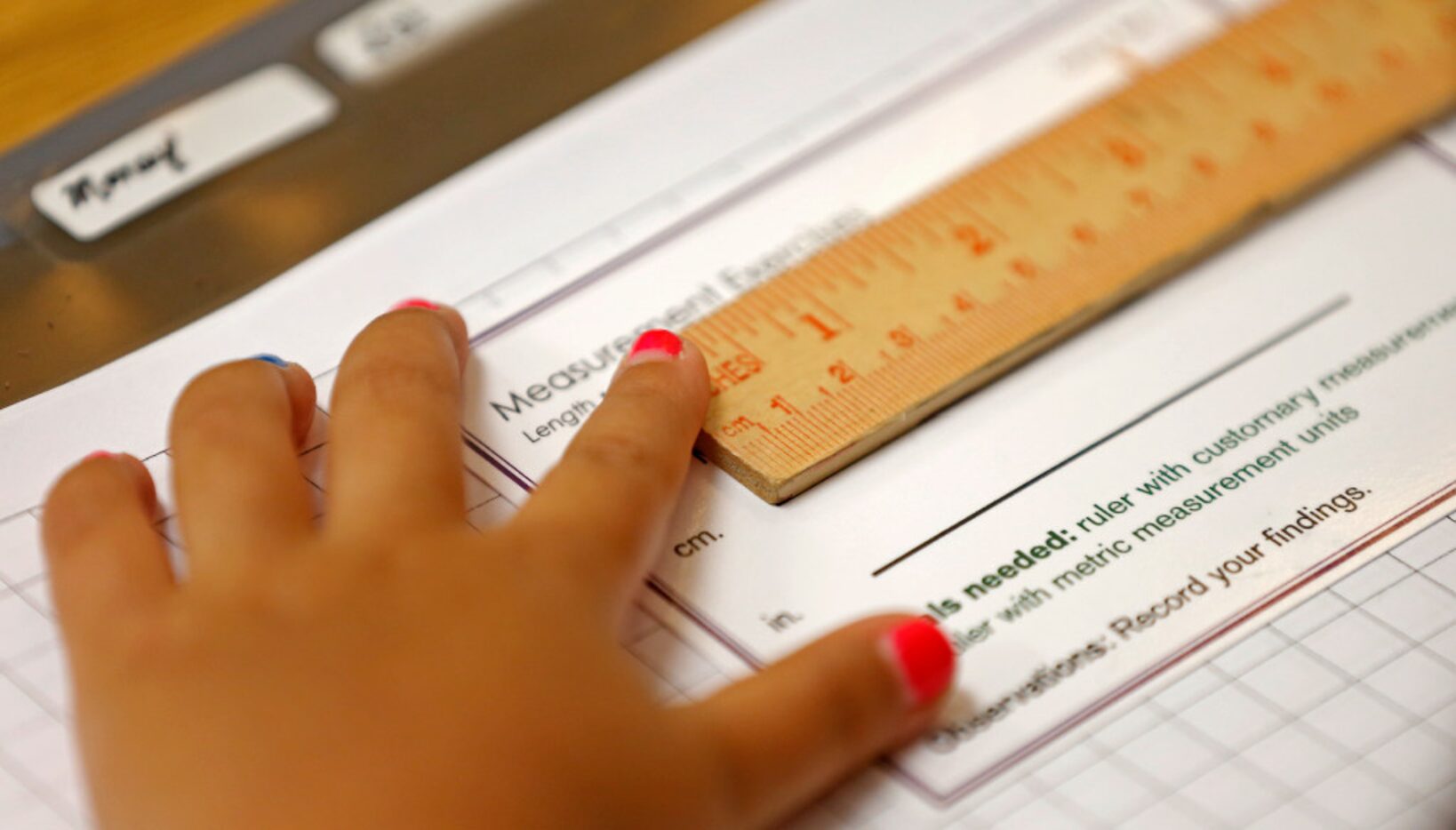 A student uses a ruler while working on her classwork during a Lower Elementary Dual...