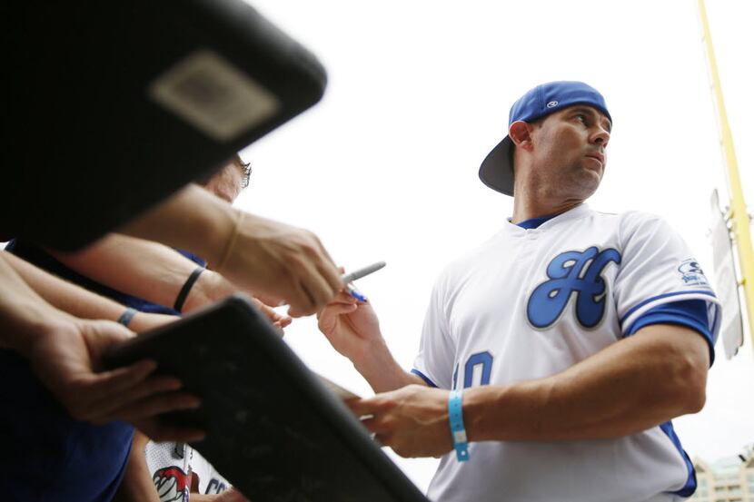 Former Texas Rangers infielder Michael Young signs his autograph for fans before Dirk...