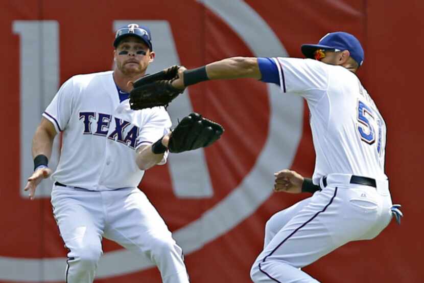 Texas Rangers right fielder Alex Rios (51) beats left fielder Craig Gentry to a pop fly by...
