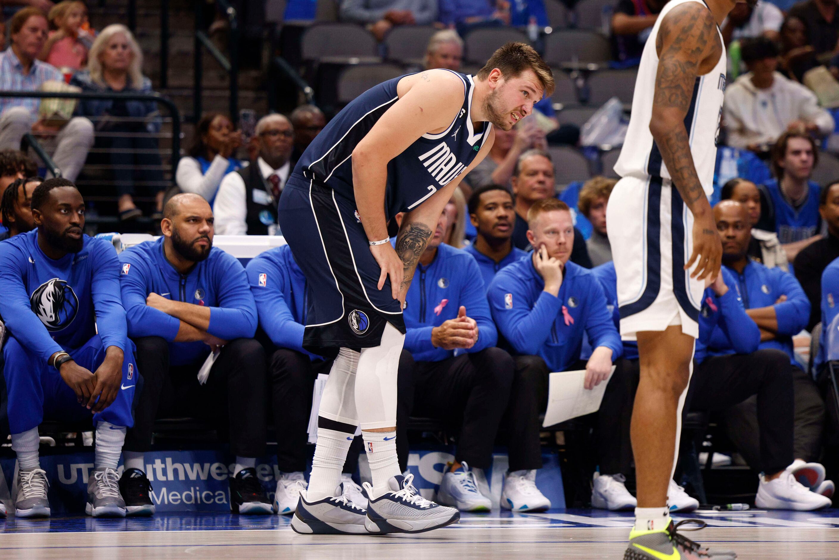 Dallas Mavericks guard Luka Doncic (77) grabs at his lower leg after appearing to injure it...