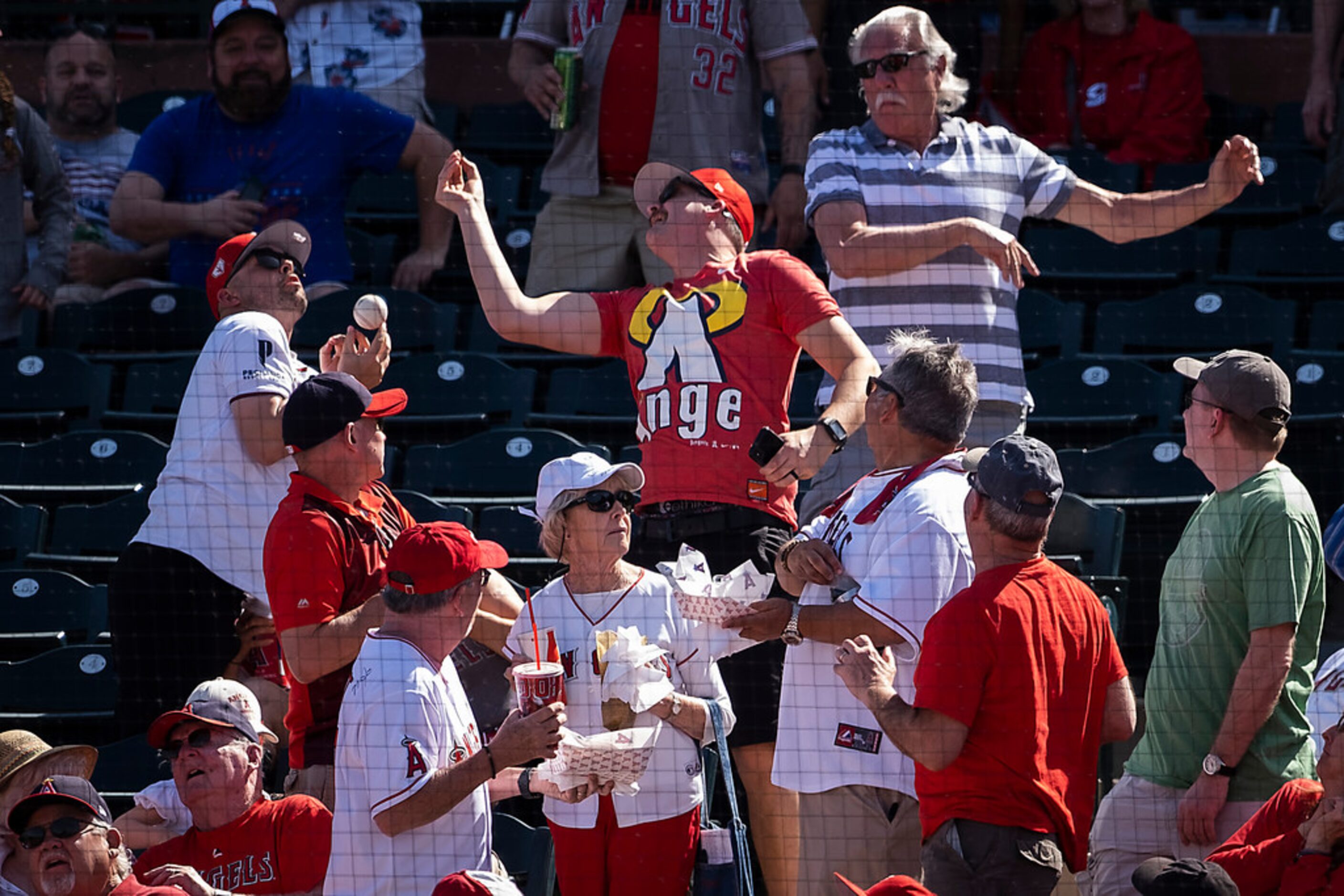 Fans try to catch a foul ball off the bat of Texas Rangers catcher Isiah Kiner-Falefa during...