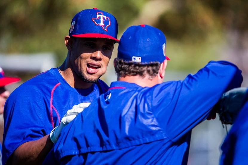 Texas Rangers center fielder Carlos Gomez (14) talks to assistant hitting coach Justin...