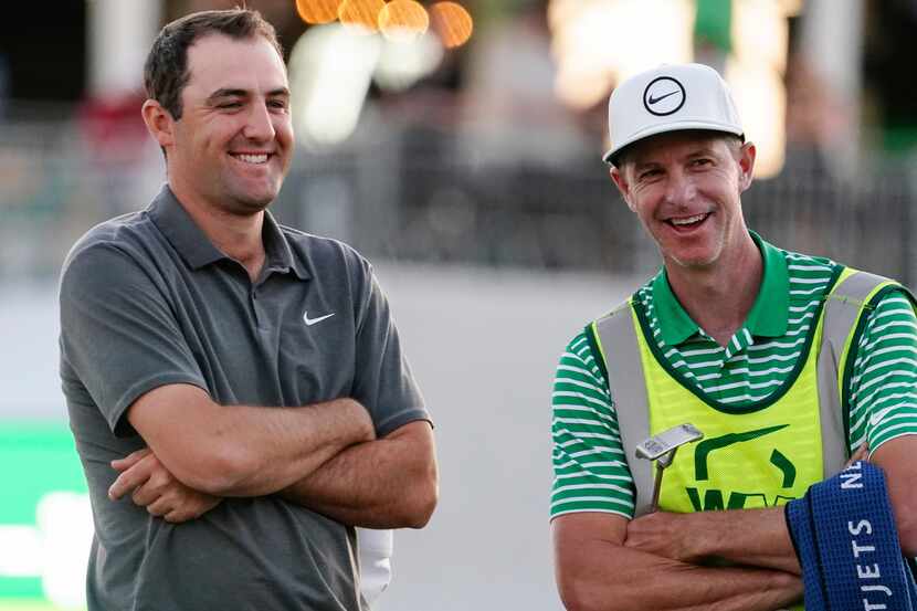 Scottie Scheffler shares a laugh with his caddy after his round during the third round of...