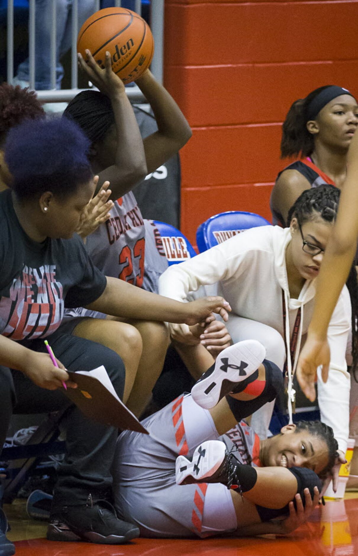 Cedar Hill guard Victoria Jackson tumbles in to the bench chasing a loose ball during the...