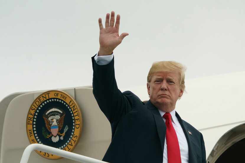 President Donald Trump waves as he boards Air Force One at Morristown Municipal Airport, in...