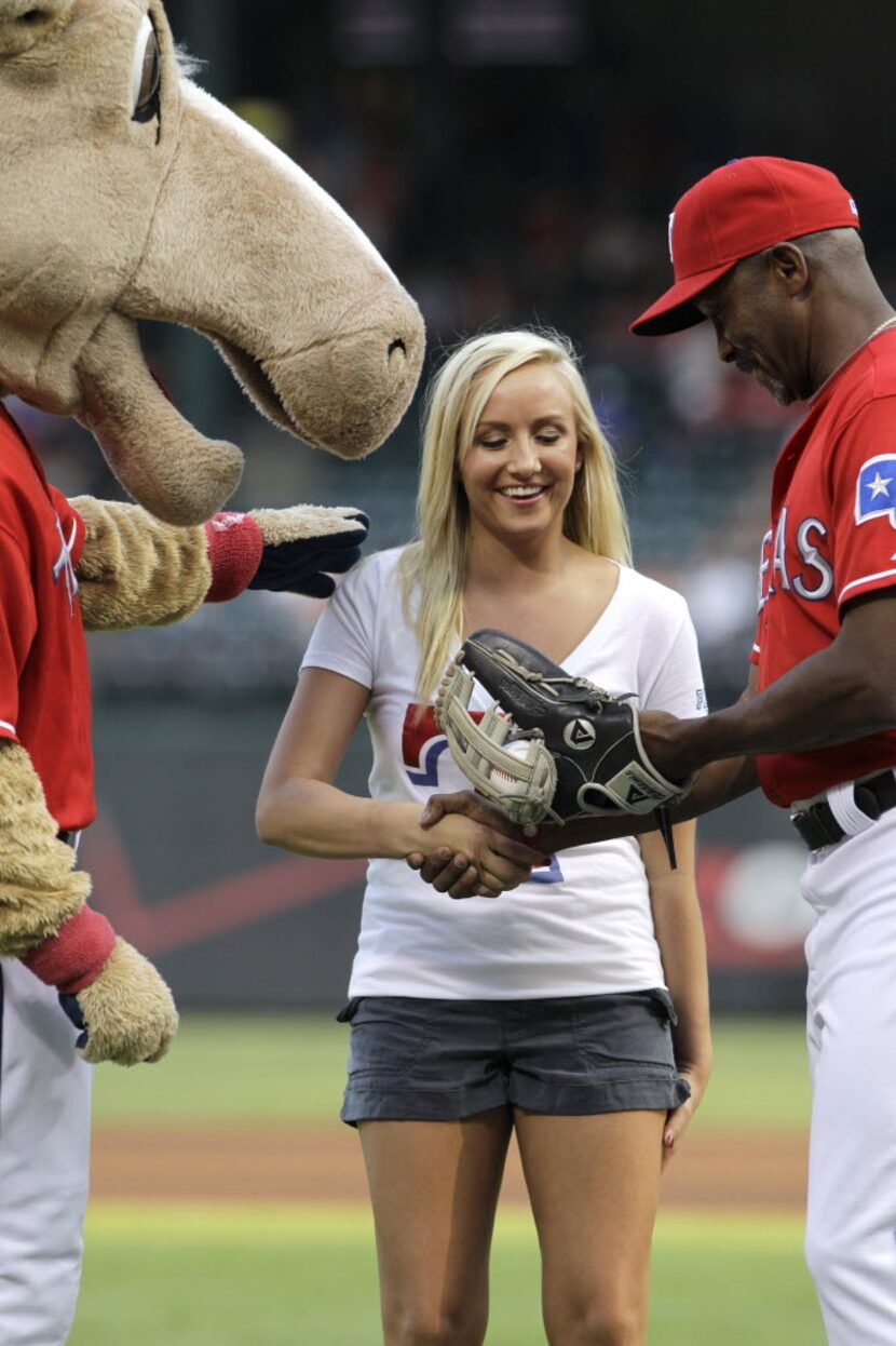 Texas Rangers mascot Captain, left, and first base coach Gary Pettis, right, shake hands...