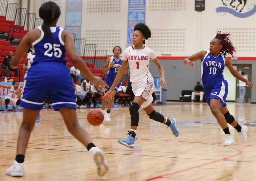 Dallas Skyline guard Jazion Jackson (1) dribbles between the defense of North Mesquite guard...