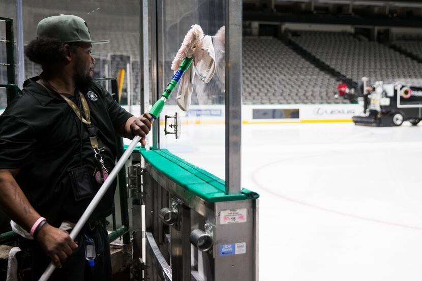 Lonnie Lockhart and other crew members clean and prepare to cover the Dallas Stars ice after...