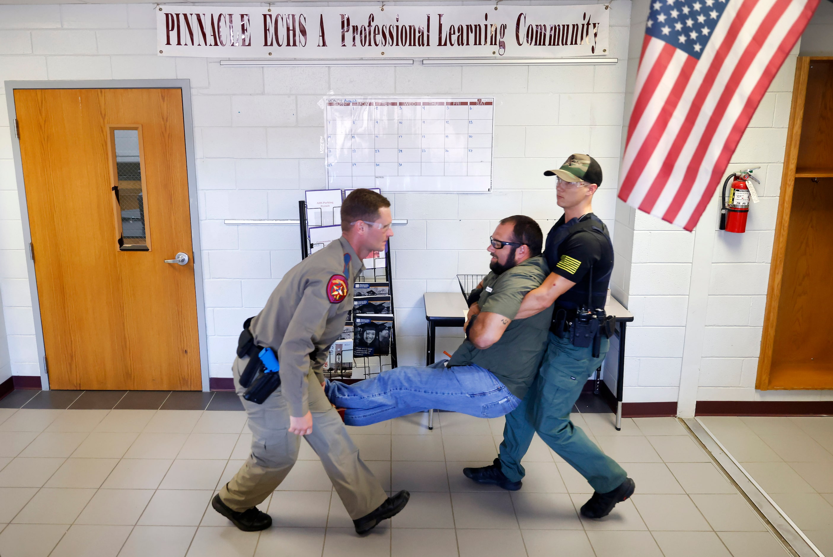 Texas DPS Trooper Chuck Pryor (left) and Athens Police Officer Travis Murdoch carry victim,...