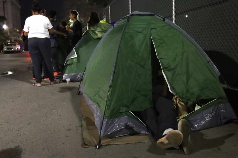 EL PASO— Migrants from Venezuela camp out in tents along the Greyhound bus station in...