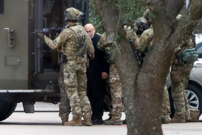 Members of the FBI escort a freed hostage at Congregation Beth Israel synagogue on Jan. 15.