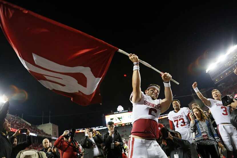 Oklahoma quarterback Baker Mayfield (6) waves the school flag following a 31-16 win against...