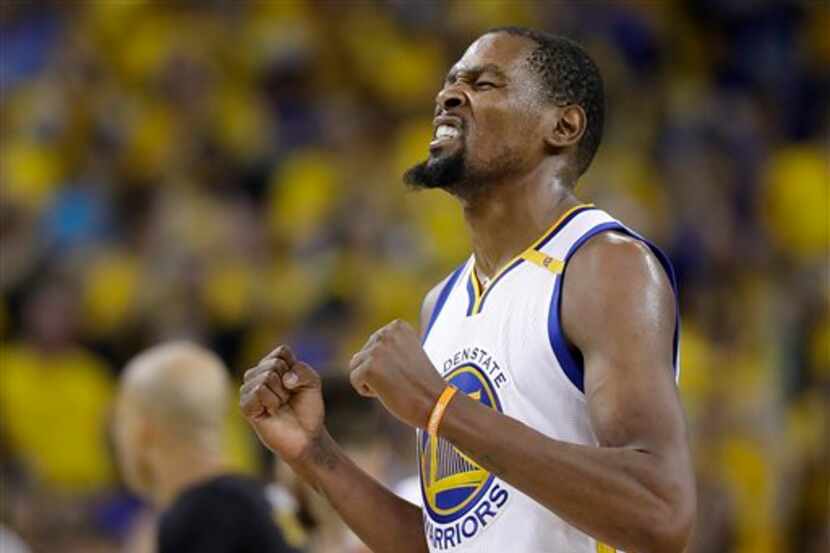 El jugador de los Warriors de Golden State Kevin Durant reacciona tras anotar frente a los...