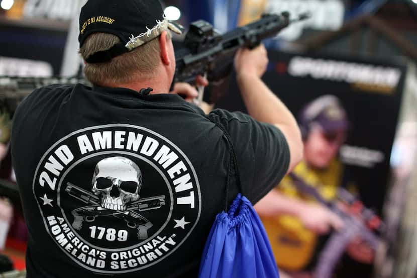 An attendee inspectss an assault rifle during the 2013 NRA Annual Meeting and Exhibits at...
