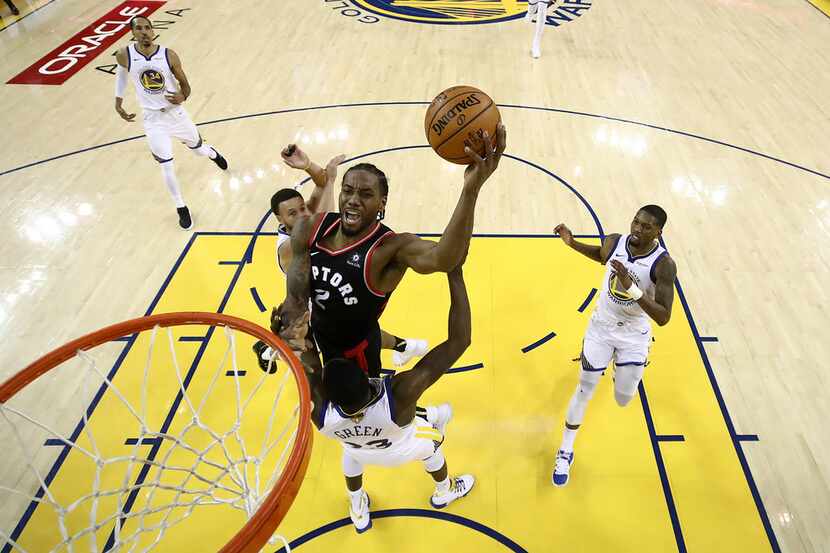 Toronto Raptors forward Kawhi Leonard, center, shoots against the Golden State Warriors...