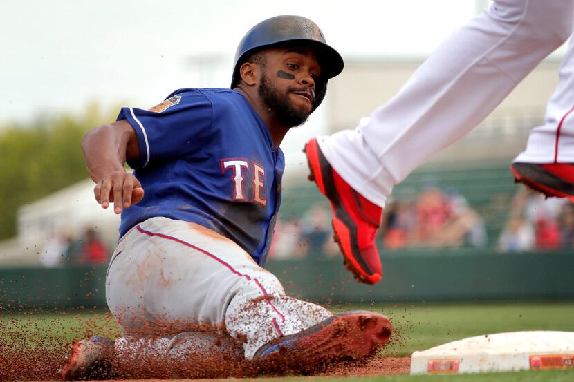 Texas Rangers' Delino DeShields steals third base during the first inning of a spring...