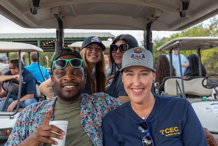 CEC Companies workers sit in a golf cart.