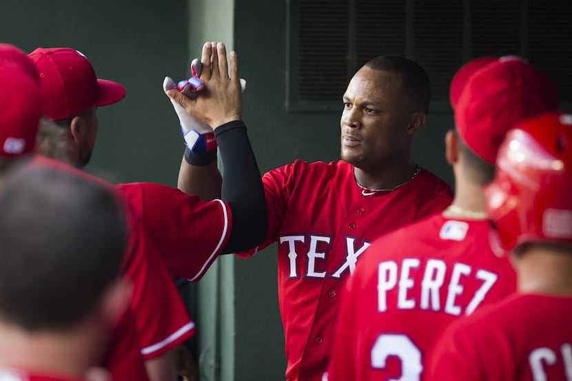 Texas Rangers third baseman Adrian Beltre gets a hand in the dugout after hitting a two-run...