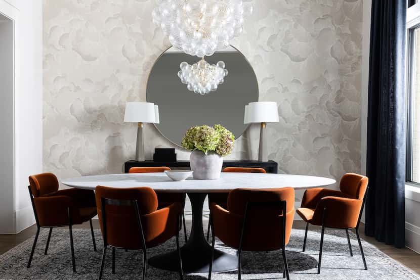 Dining rom with white table, rust-colored chairs and bubble glass chandelier