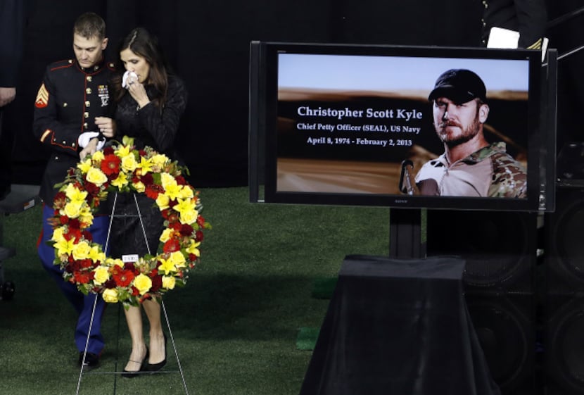 A member of the military consoles Taya Kyle after speaking at the memorial service for her...