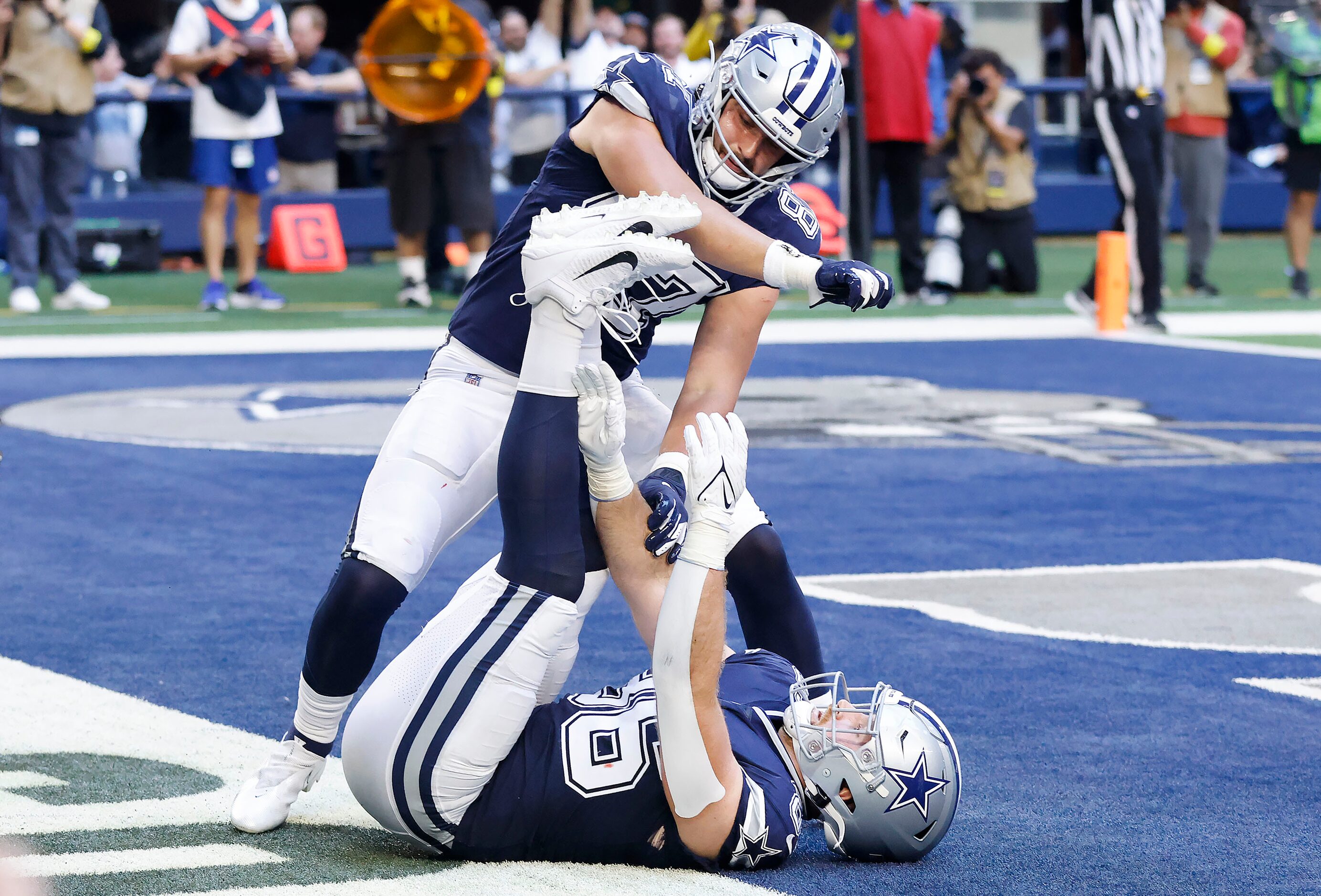 Dallas Cowboys tight end Jake Ferguson (87) mimics wrapping up Dalton Schultz’s (86) feet...