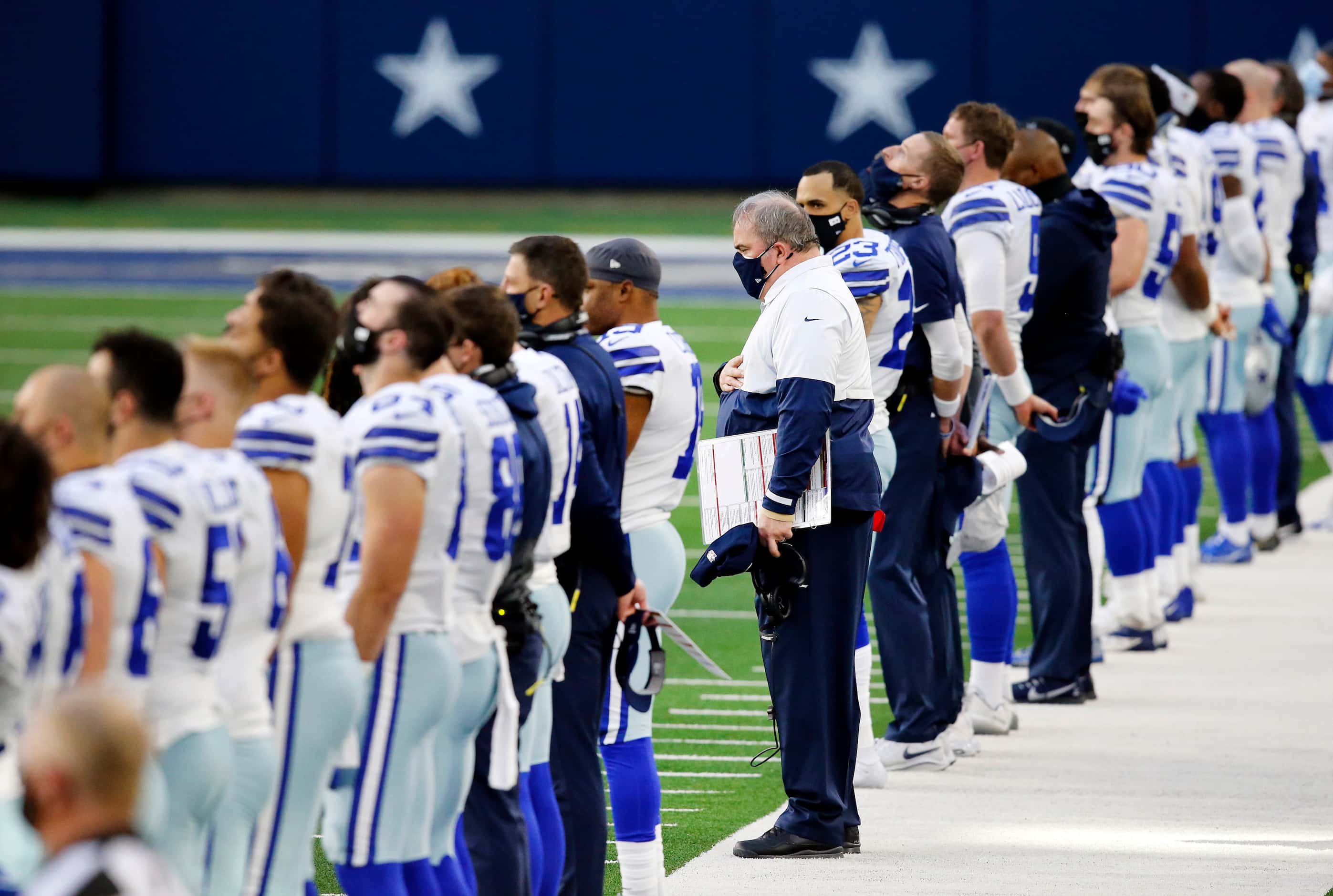 Dallas Cowboys head coach Mike McCarthy (center) lines up with his players for the national...