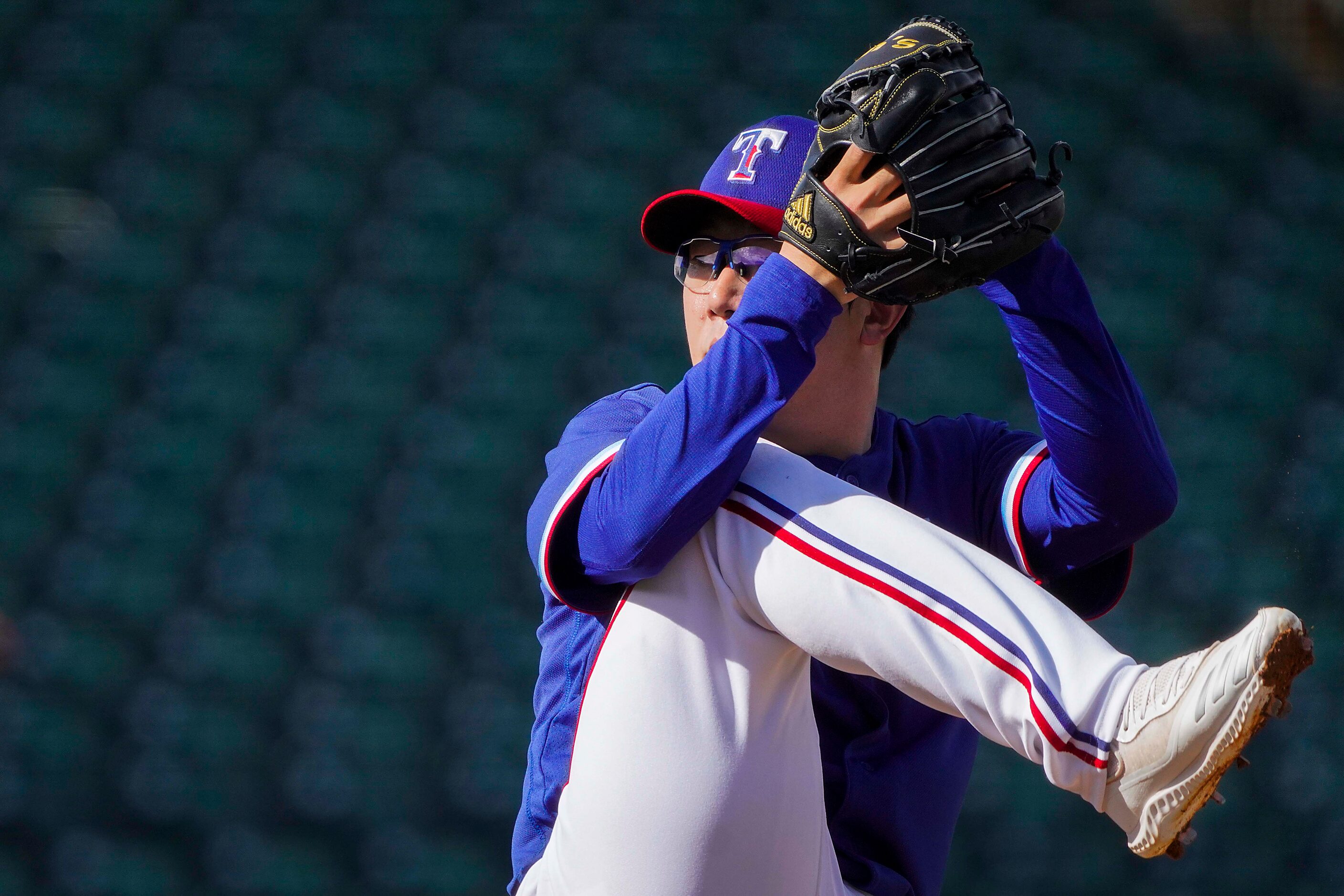 Texas Rangers pitcher Hyeon-jong Yang delivers during the eighth inning of a spring training...