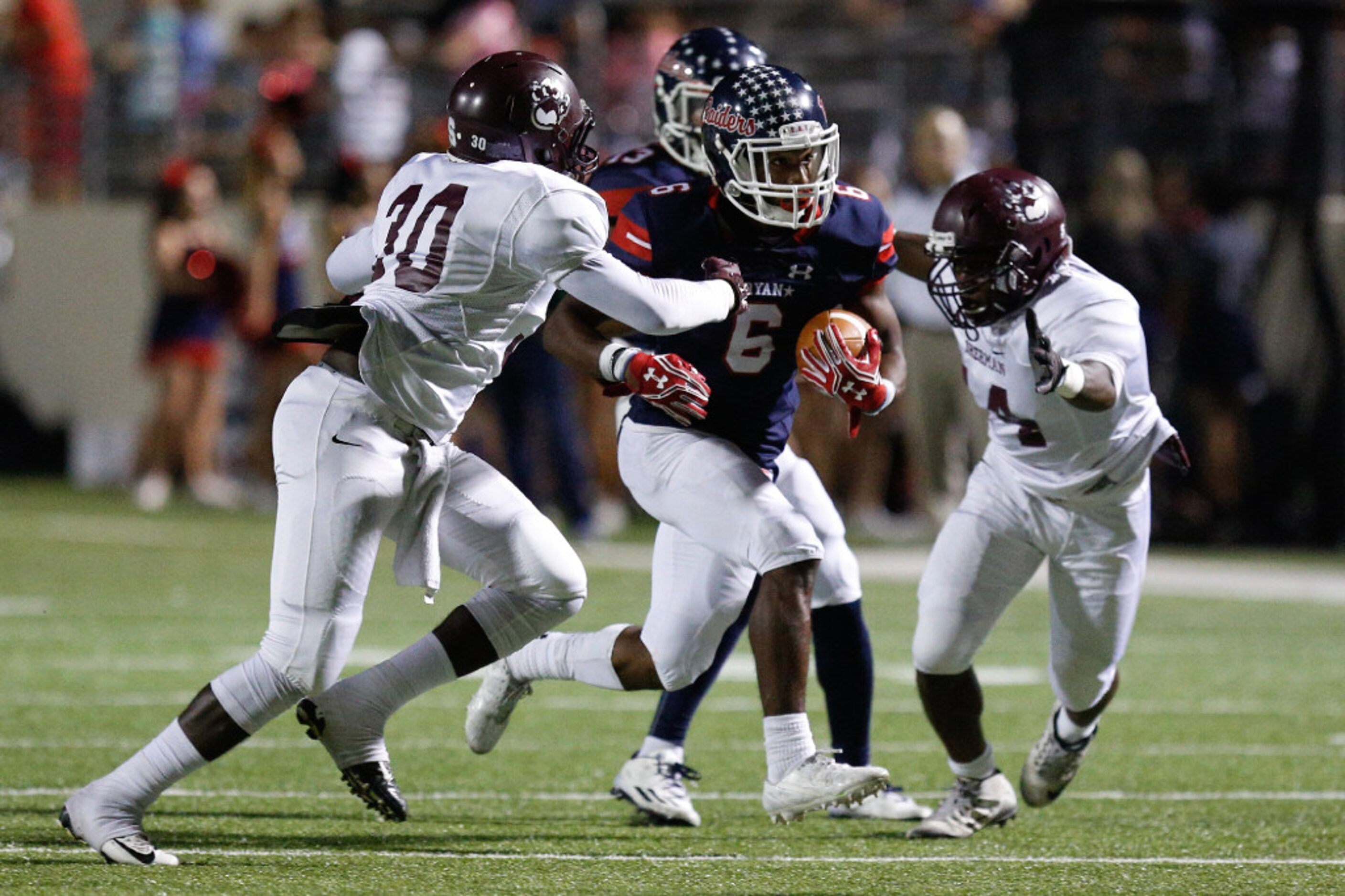 Ryan junior running back Tamar Butts (6) runs the ball and tries to avoid tackles from...